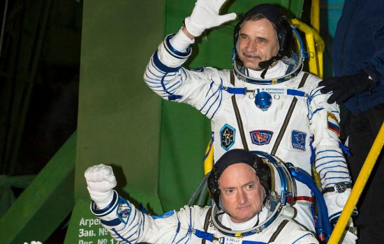 Russian cosmonaut Mikhail Kornienko of the Russian Federal Space Agency (top) and NASA astronaut Scott Kelly, wave farewell as they board the Soyuz TMA-16M spacecraft ahead of launch.