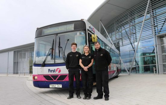 AMRC apprentices Sean Goodwin of Nikken and Abbie Plumer of Symphony Group PLC with AMRC Trainer Gareth Wilkinson and their new bus.