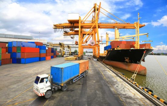 Industrial Container Cargo freight ship with working crane bridge - image courtesy of Depositphotos.
